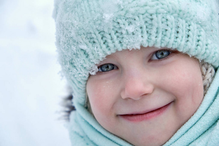一个小女孩的脸上的户外肖像在冬季关闭的帽子