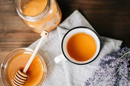 平躺顶观杯草药茶与圣人和蜂蜜与勺子在玻璃碗上的质朴木质背景, 健康饮料