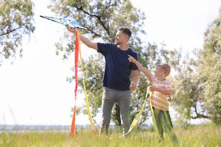 小男孩和他的爸爸在户外放风筝图片