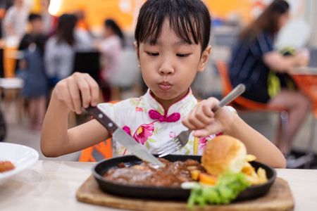 亚洲华人小女孩在餐厅吃西餐图片