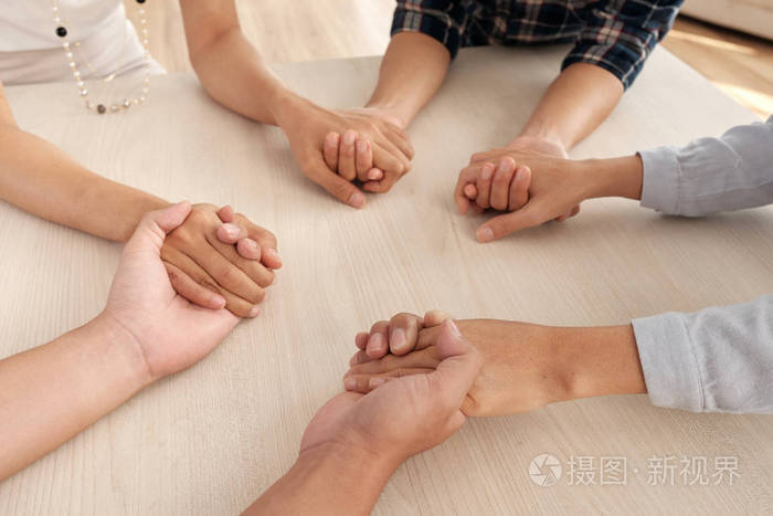 一群人互相扶持, 手拉手在餐桌上