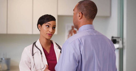 一名黑人医生在她的办公室里为一名非洲裔美国人患者提供建议