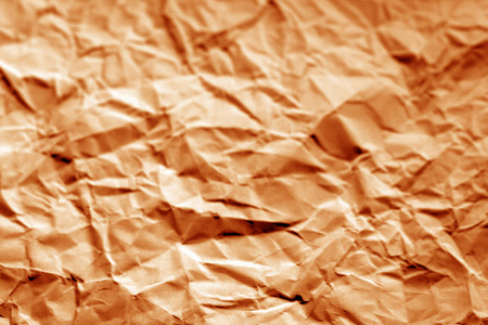 在橙色色调的模糊效果的皱巴巴的纸页。设计的抽象背景和纹理