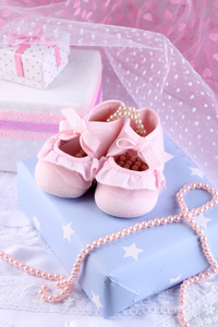 粉红色的宝宝靴与礼物特写