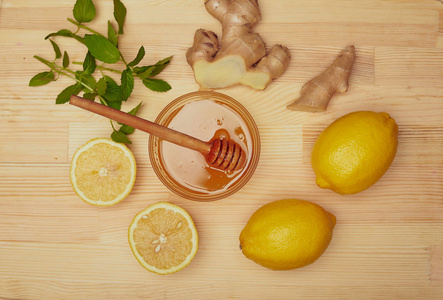 蜂蜜在碗, 生姜, 柠檬和薄荷在木板上
