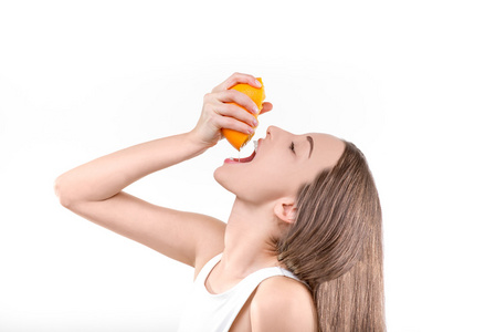 年轻的女孩，紧迫的 从橙色喝果汁