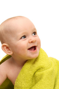 微笑着裹在白色背景上绿色毛巾的小宝宝