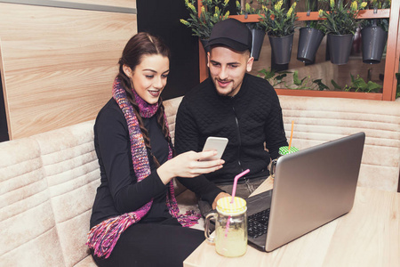 幸福的夫妇或朋友一起使用智能手机和喝柠檬水在咖啡馆