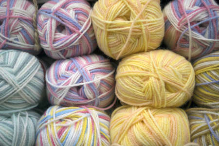许多五颜六色的羊毛捆排列在商店货架上的行, 纱线纹理