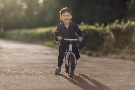 快乐男孩骑自行车在公园和看照相机