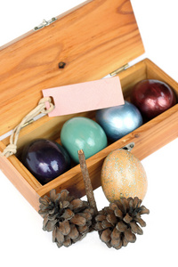 复活节快乐。在白色背景上的木盒子的复活节彩蛋