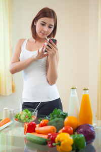 年轻女子以下食谱上移动电话