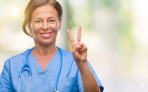 中年资深护士医生妇女在孤立的背景显示和指着手指第二, 而微笑着自信和快乐