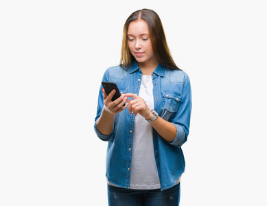 年轻美丽的白种人妇女发短信发送消息使用智能手机在孤立的背景与自信的表达在聪明的脸上思考严肃