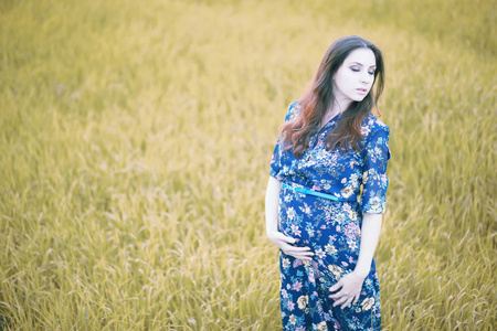 怀孕的女孩在自然的礼服
