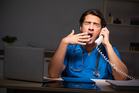 年轻英俊医生夜班在医院照片