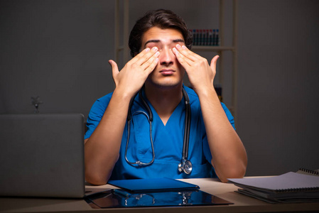 年轻英俊医生夜班在医院照片