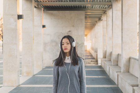 年轻漂亮的中国女孩，戴着耳机