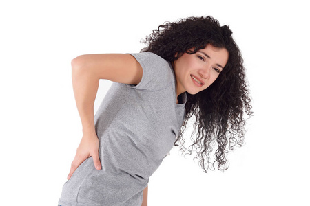 年轻的拉丁妇女背部疼痛, 抱着她疼痛的背部。在白色背景上被隔离