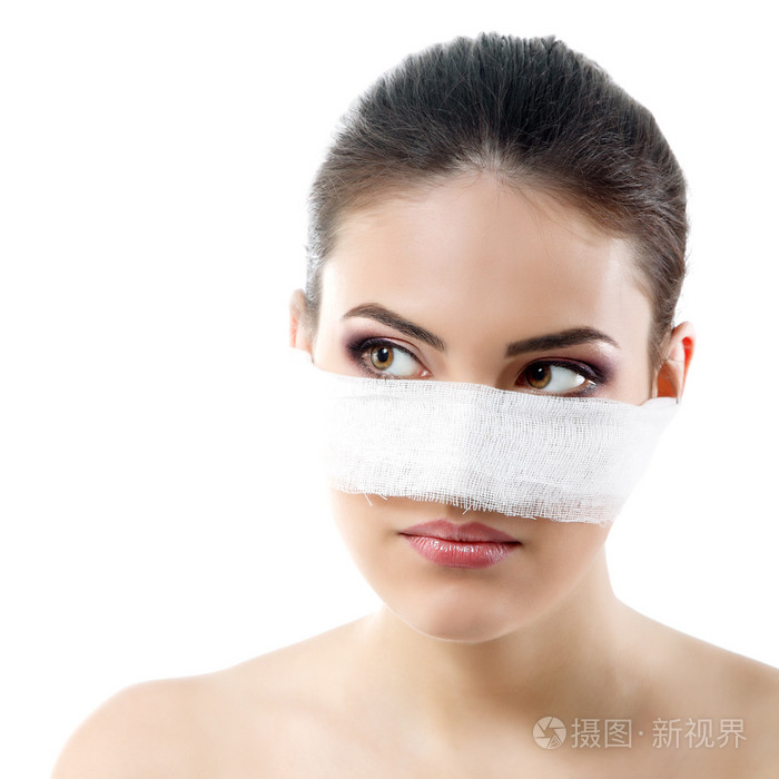 美丽年轻的女性脸,用她的鼻子上的绷带的肖像