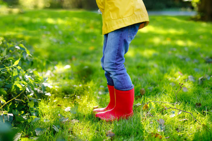 在不同的橡胶靴, 牛仔裤和夹克的男孩或女孩的学校或学前腿特写镜头.