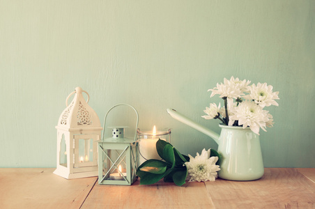 夏季束鲜花和老式灯笼与薄荷背景木制的桌子上。老式的滤波的图像