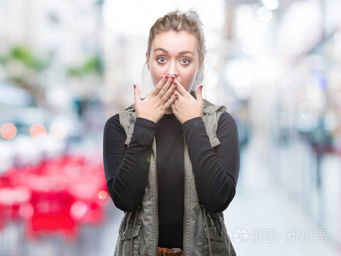 在孤立的背景下, 年轻的金发女郎震惊地捂住嘴巴, 误了手.秘密概念