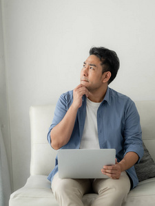 压力亚洲男人在家里使用笔记本电脑, 生活方式的概念与复制空间