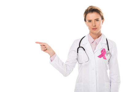 医生与粉红色丝带指着手指, 看着相机孤立的白色, 乳腺癌意识的概念