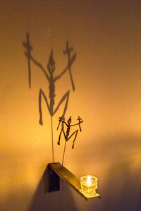 假日反射有十字架的骷髅的神话般的影子从蜡烛的火焰上反射到墙上.