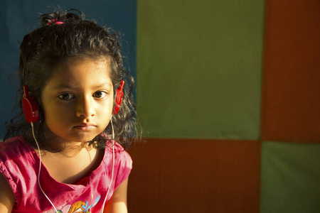 小女孩用红色耳机听音乐的特写镜头, 浦那, 马哈拉施特拉邦, 印度