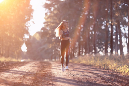 有魅力的女人在秋天的森林里奔跑。年轻运动妇女户外慢跑