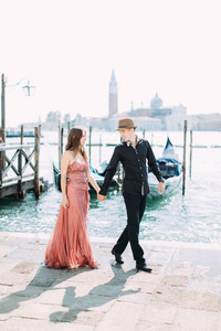 情侣在威尼斯蜜月期间沿着海滨散步