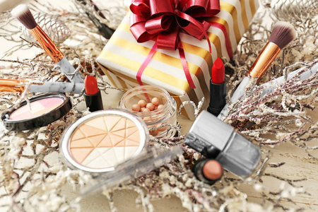 一套装饰性化妆品与圣诞礼物和花圈在白色木桌