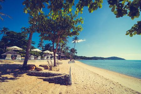 美丽的热带海滩和海与椅子在蓝天为旅行和假期
