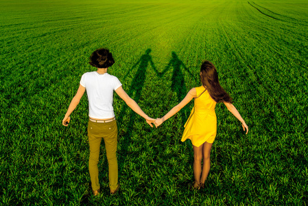 年轻的夫妇在绿色的原野上尽情的在春天或汇总