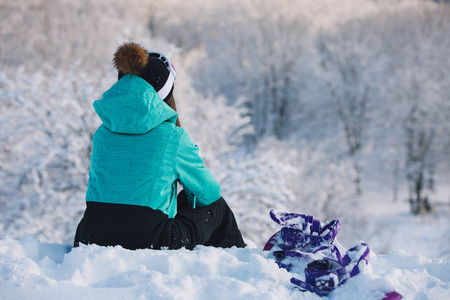 妇女滑雪坐在高山和休息