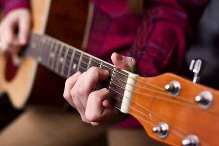 用手指玩吉他女孩或女人有长.手指在弦上的立场.选择性聚焦图像照片