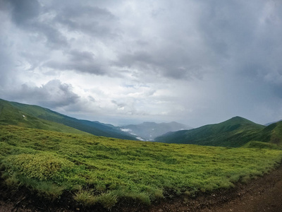 乌克兰夏季绿色的山脉。天空越过群山。乘吉普车旅行时的大气景观。越野远征