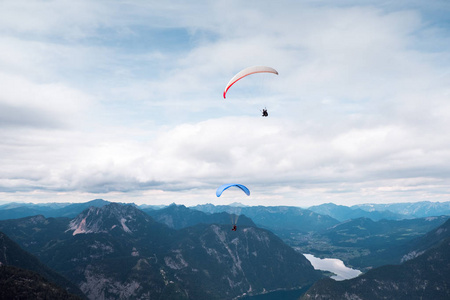 滑翔在湖在奥地利阿尔卑斯 壮观蓝色海与岩石山在日出期间