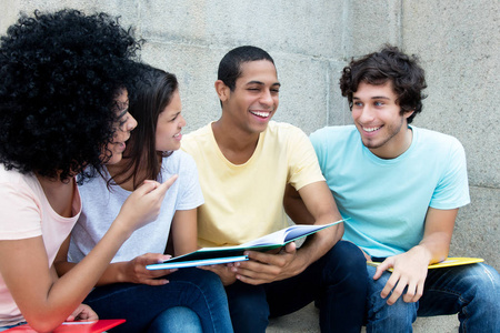 白种人和非洲和拉丁学生夏天在大学校园里一起学习户外活动