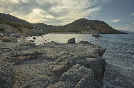 美丽的地中海海滩典型的南部撒丁岛海岸接管在夏季。海滩岩石和后面的山融合在一个惊人的美丽的美妙全景中