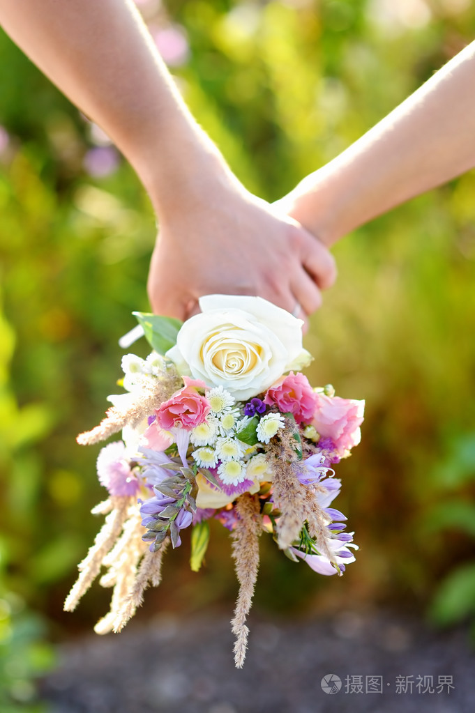 对夫妇抱着野生鲜花花束