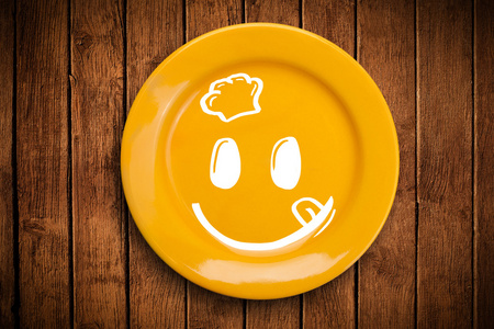 快乐卡通笑脸多彩的菜盘子照片