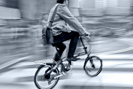 在交通在城市巷道运动模糊和蓝色吨骑自行车的人