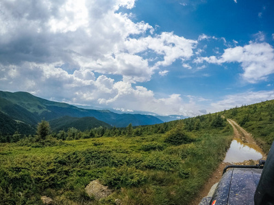 乌克兰夏季绿色的山脉。天空越过群山。乘吉普车旅行时的大气景观。越野远征。从窗口查看