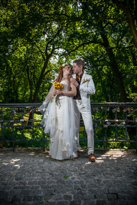在白色的衣服，在公园中拥抱的已婚的夫妇