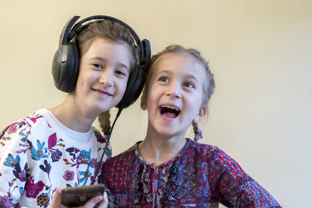 两个小快乐的女孩一起听音乐