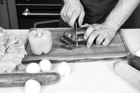 蔬菜被切成木制的切板。手切片胡椒粉用陶瓷刀。食物准备和烹饪食谱。素食食谱和健康饮食。有机产品理念