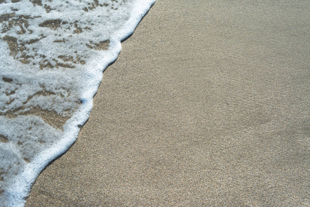 夏日阳光明媚的沙滩上的海浪特写